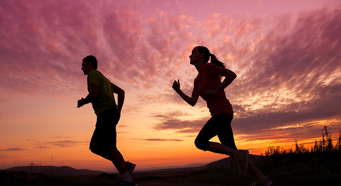 Two runners at sunset.