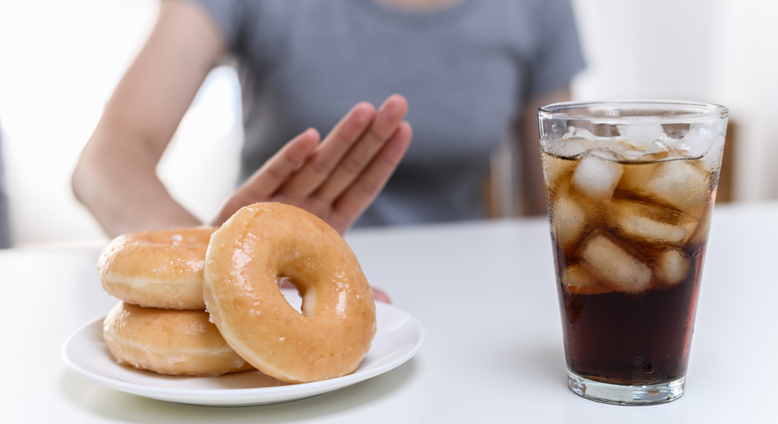 Person saying no to donuts and soft drink