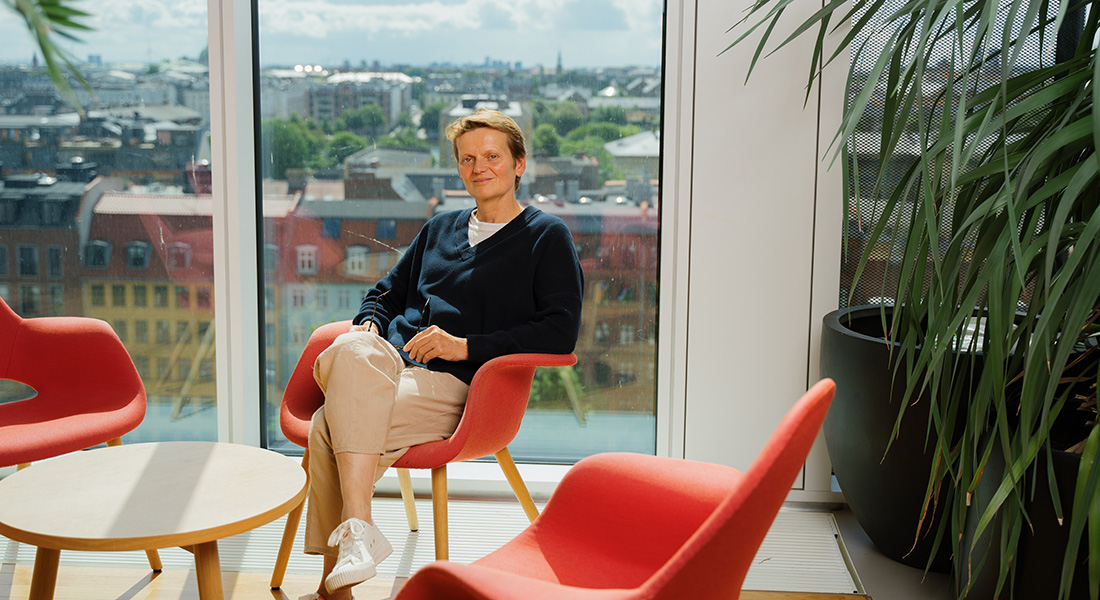 Photo of Ruth Loos sitting in a red chair Photo of Ruth Loos sitting in a red chair