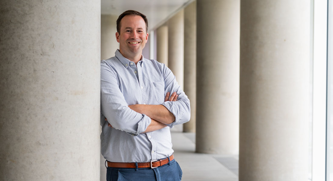 Photo of Zach Gerhart-Hines leaning against a concrete column
